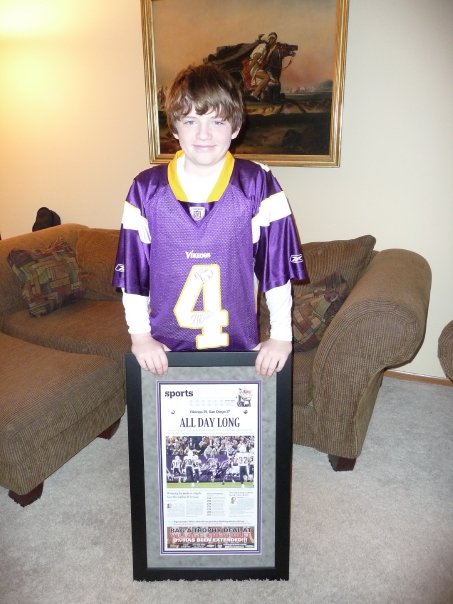 Boy holding framed newspaper