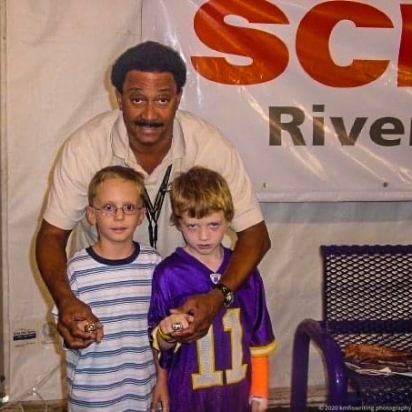 Two boys with Minnesota Vikings player Chuck Foreman