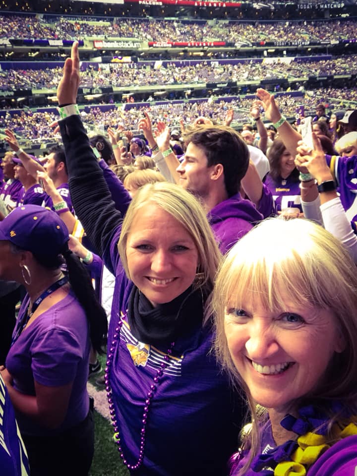 Two women dancing on football field during halftime show