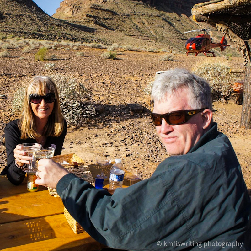 Couple drinking champagne on the floor of the Grand Canyon