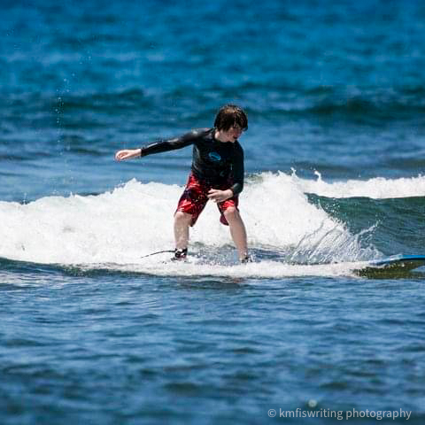 Boy surfing in Maui Hawaii